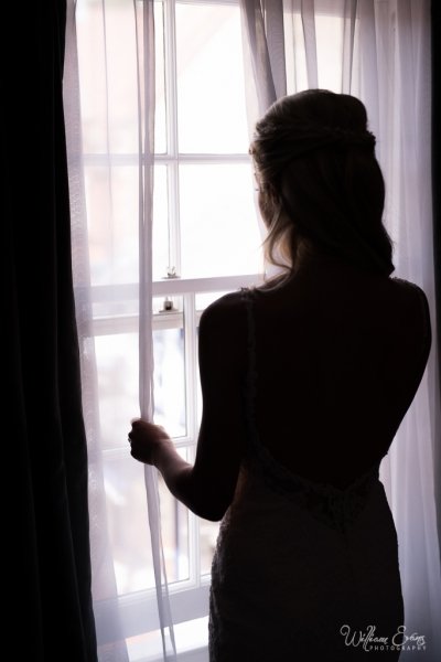 Bride looking out of the window - William Evans Photography