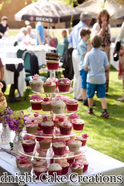 Cupcake tower with a variety of coordinating toppers and details for a picnic themed wedding. - Midnight Cake Creations